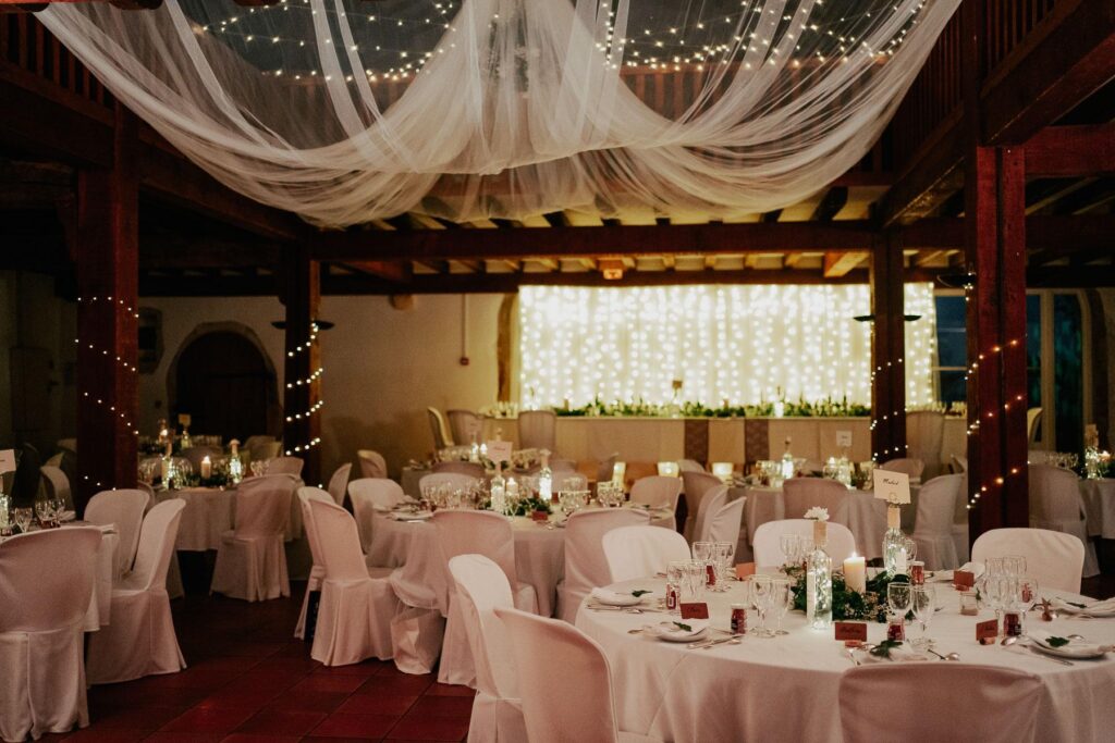 Une réception de mariage organisée par le Wedding Planner Landais avec des tables blanches et du linge de maison blanc.