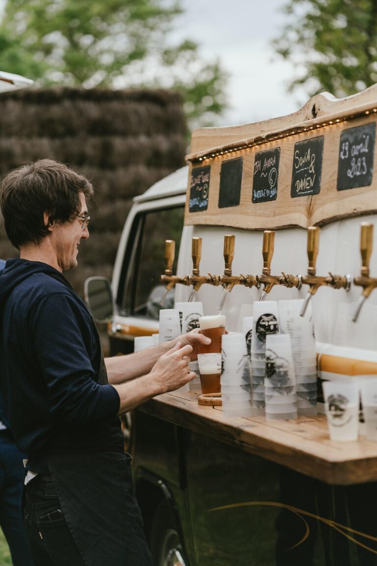 Un homme verse de la bière depuis un bus VW dans les Landes.