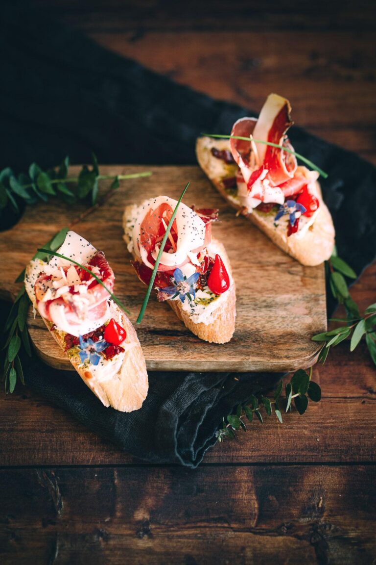 Trois bruschettas arroz y tapas sur une planche de bois.