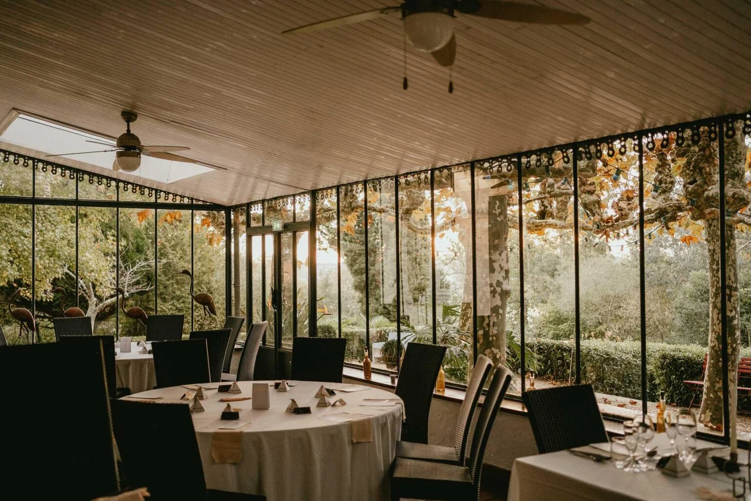 Une salle à manger avec tables et chaises dans une enceinte vitrée.