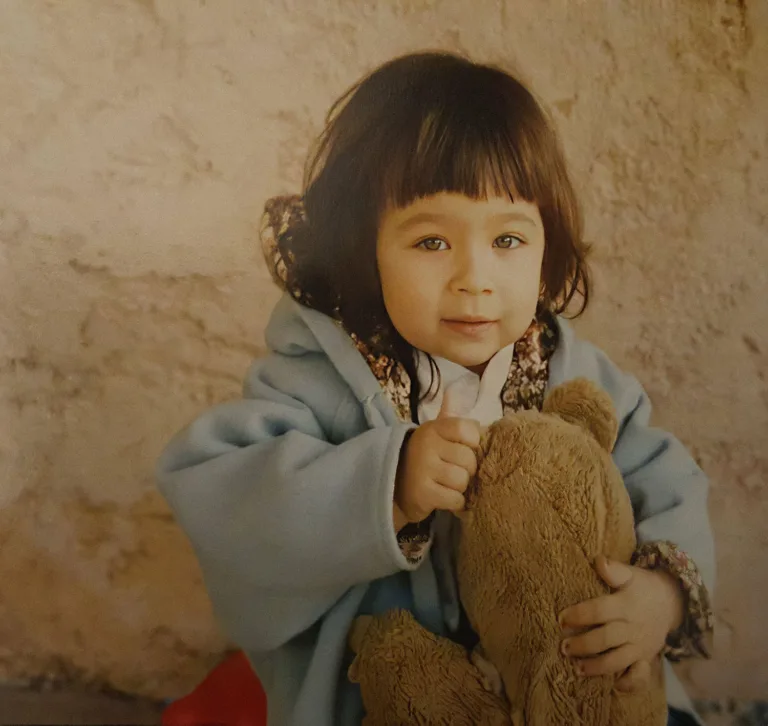 Une petite fille tenant un ours en peluche pour un test.