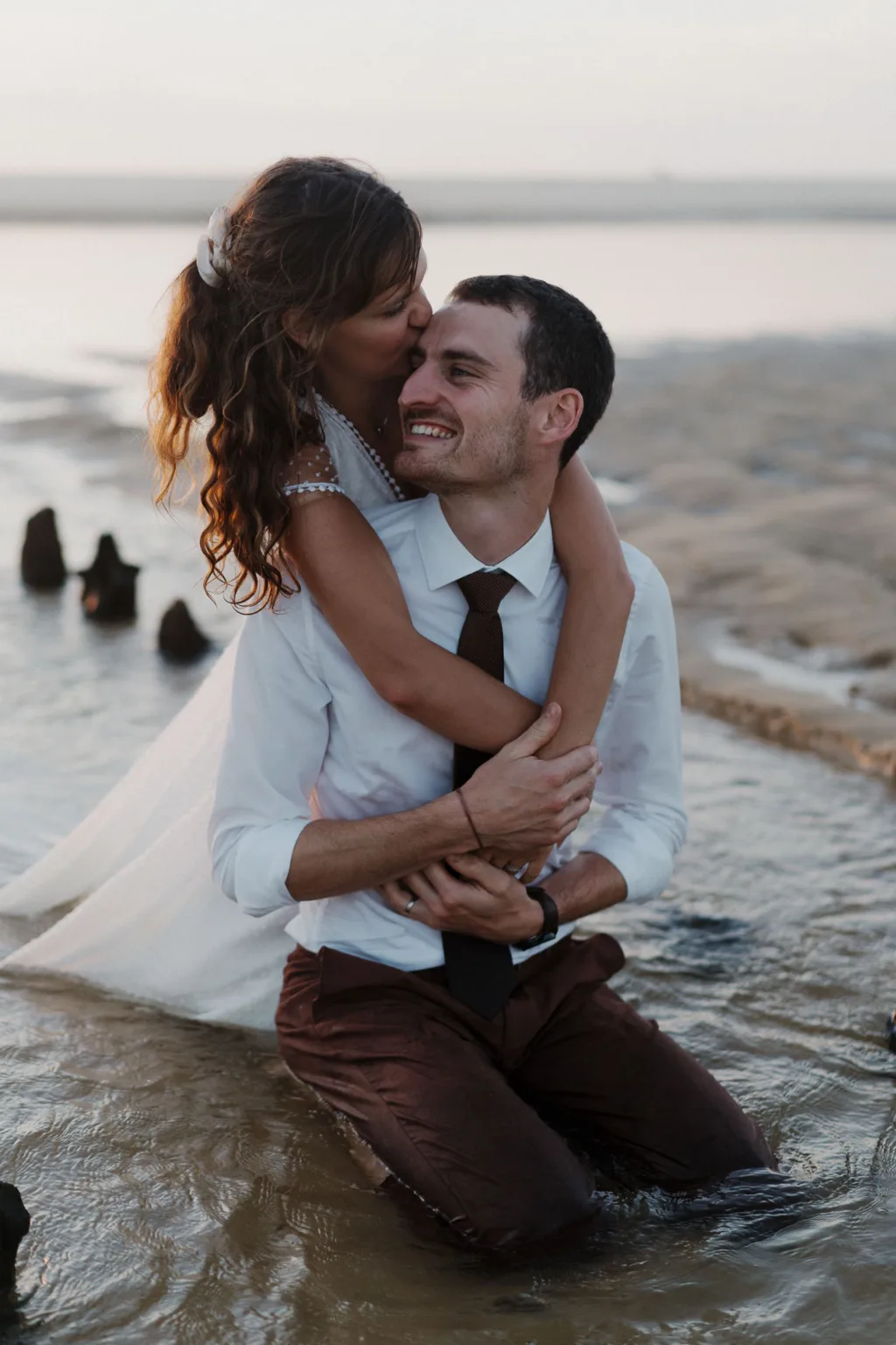 Couple se tenant au bord de l’eau à Seignosse, paysage majestueux.