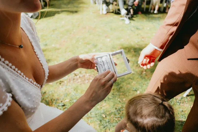 Des mariés tenant une carte de mariage à la main à la Grange de Meysonnave.