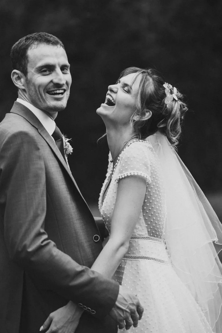 Une photo en noir et blanc des mariés riant à la grange de mariage de Meysonnave.