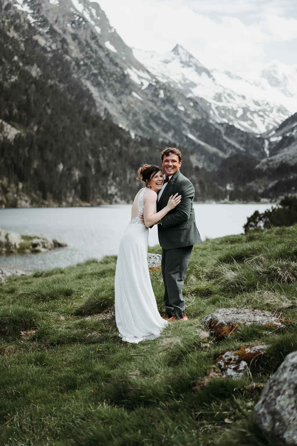 Couple en manteau au bord d’un lac alpin, complicité hivernale.