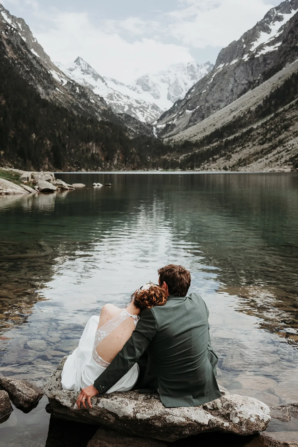 Couple enlacé face à un lac de montagne, séance after-day épique.