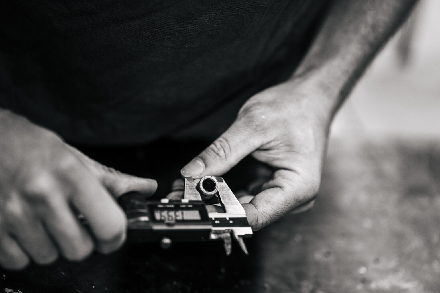 Cette image captivante capture un gros plan sur des mains expertes utilisant un pied à coulisse pour mesurer avec précision le diamètre d'un petit tube métallique, évoquant les outils minutieux d'un artisanat délicat que l'on pourrait apprécier lors de paisibles vacances dans les Landes, parfait pour illustrer l'attention aux détails et le savoir-faire exceptionnel recherché par les photographes de mariage et de famille désireux d'immortaliser des moments précieux et authentiques dans cette magnifique région.
