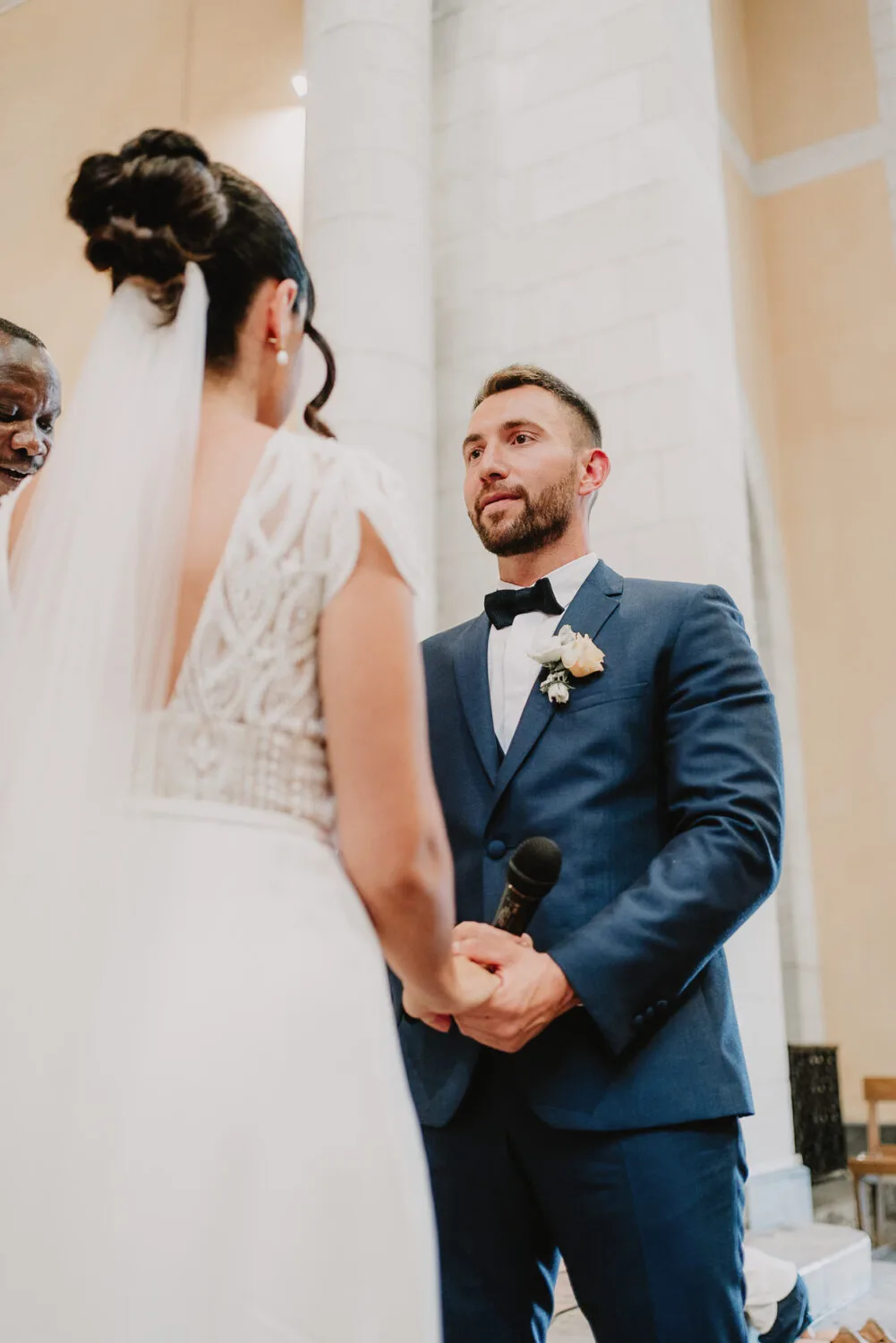 Au cœur d'une cérémonie de mariage émouvante, un marié locataire un microphone et une mariée se font face, échangeant des salutations remplies d'amour et de joie sous l'objectif expert du photographe de mariage et famille à Soustons, offrant ainsi une illustration parfaite de la magie des unions célébrées dans les Landes.