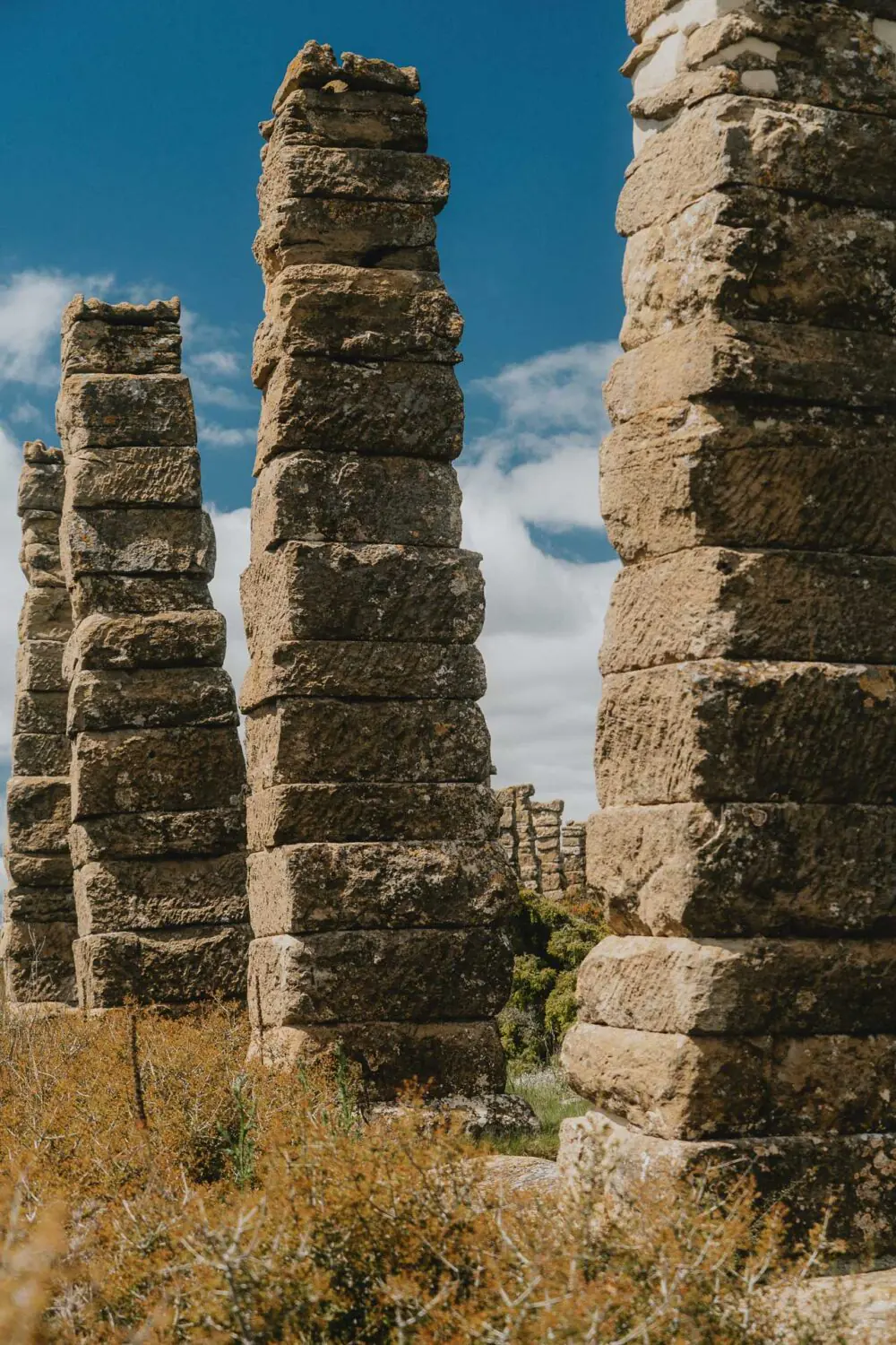 De hauts piliers de pierre, témoins du temps, se dressent dans la nature sauvage sous un ciel doux et lumineux d'espagne.