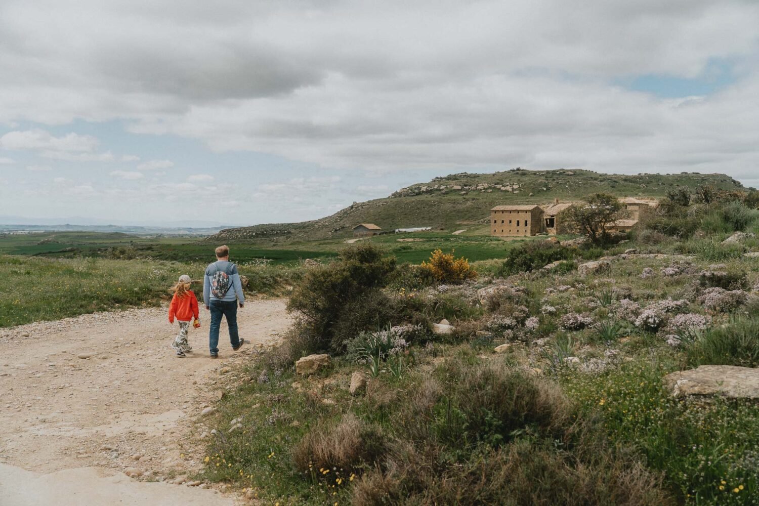Une balade main dans la main, entre collines et vieilles pierres, capturant la douceur d'un moment en famille en Espagne.