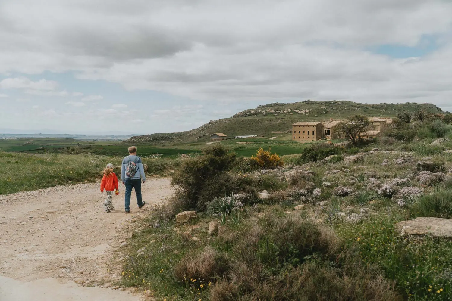 Une balade main dans la main, entre collines et vieilles pierres, capturant la douceur d'un moment en famille en Espagne.