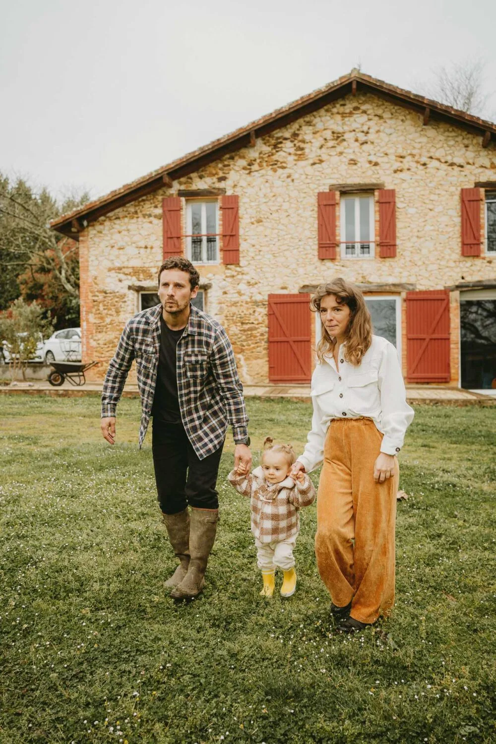 Un tendre moment en famille devant une maison landaise, naturelle et authentique, idéal pour un reportage de famille.