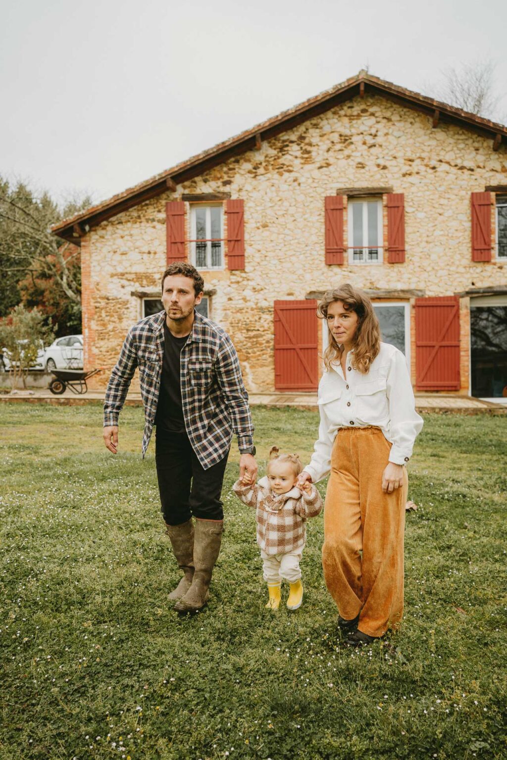 Un tendre moment en famille devant une maison landaise, naturelle et authentique, idéal pour un reportage de famille.