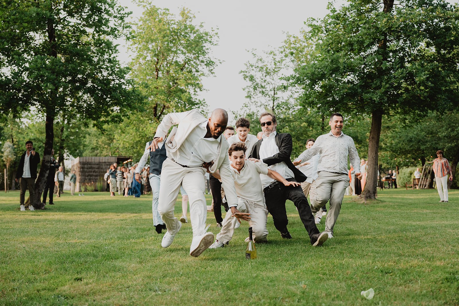 Instant complice sur la pelouse du domaine de Petiosse, hommes et garçons s'élancent joyeusement lors d'un jeu entre proches.