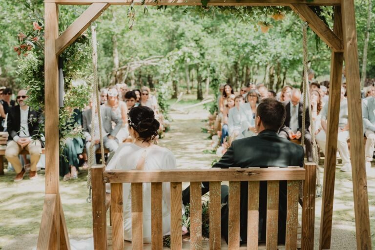 Céline et Nicolas savourent un doux moment sur une balançoire, entourés de verdure au domaine de Petiosse, ambiance intime.