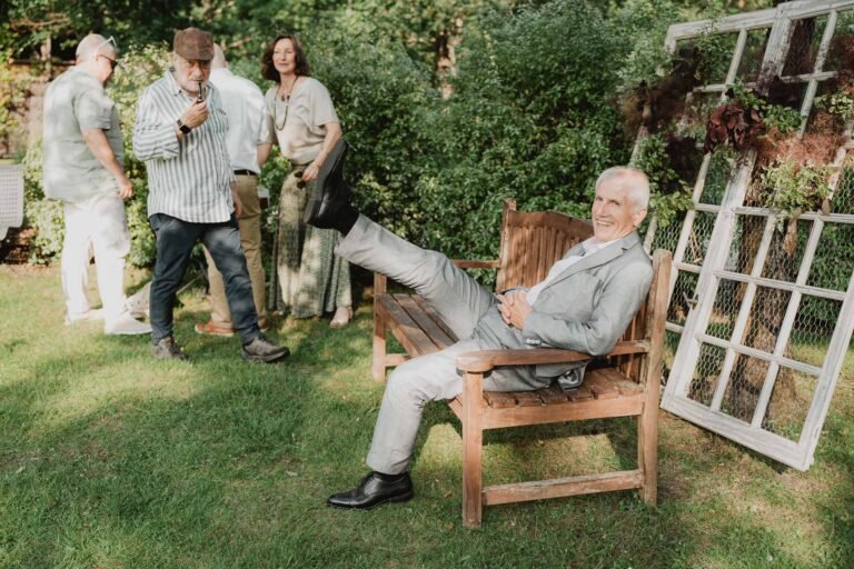 Scène douce au jardin du Domaine de Petiosse : aîné sur banc, famille réunie dans une ambiance chaleureuse et naturelle.