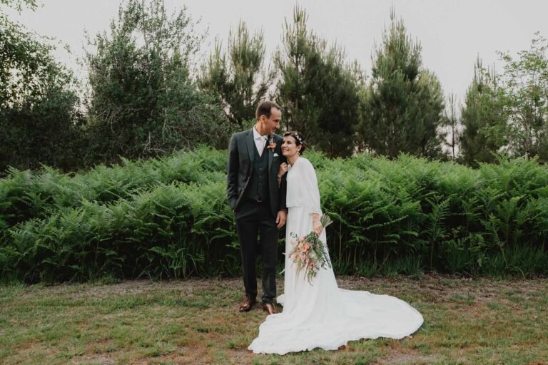 Céline et Nicolas, radieux, posent enlacés au Domaine de Petiosse, entourés de verdure pour un instant doux et authentique.