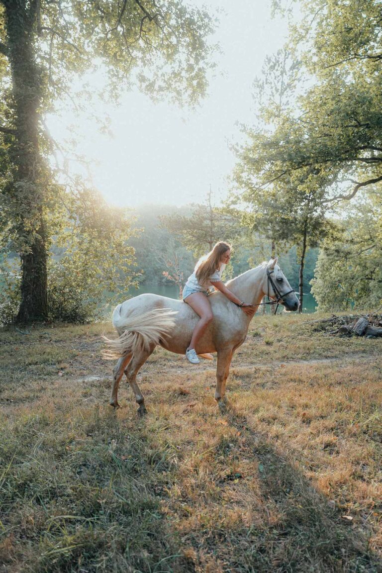 Instant tendre dans les Landes : une jeune fille à cheval au naturel, lumière douce en clairière près du domaine de mariage.