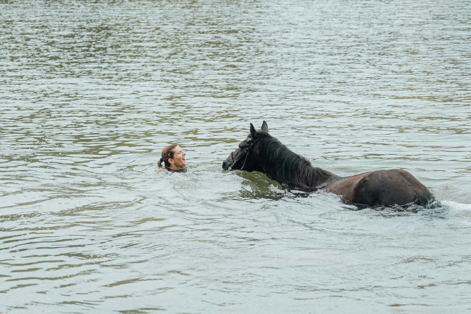 Imaginez une douce harmonie : un proche et son cheval nagent ensemble, moment complice, ambiance mariage dans les Landes.