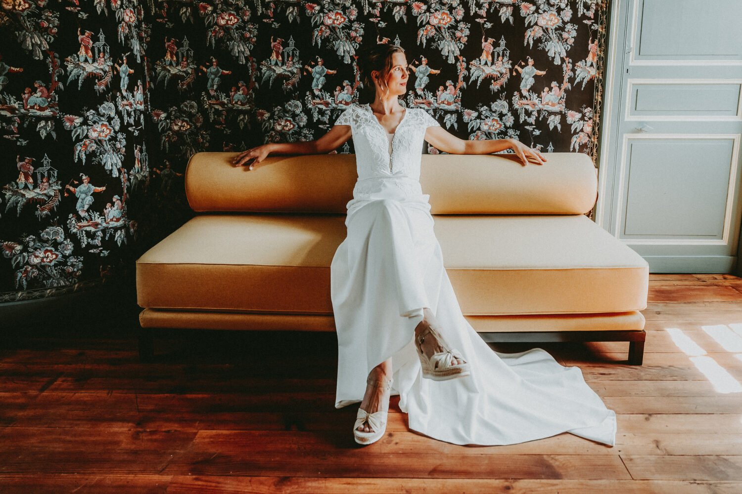 Instant de douceur capturé lors d'un mariage dans les Landes : la mariée rayonne, assise sur un canapé, ambiance élégante.
