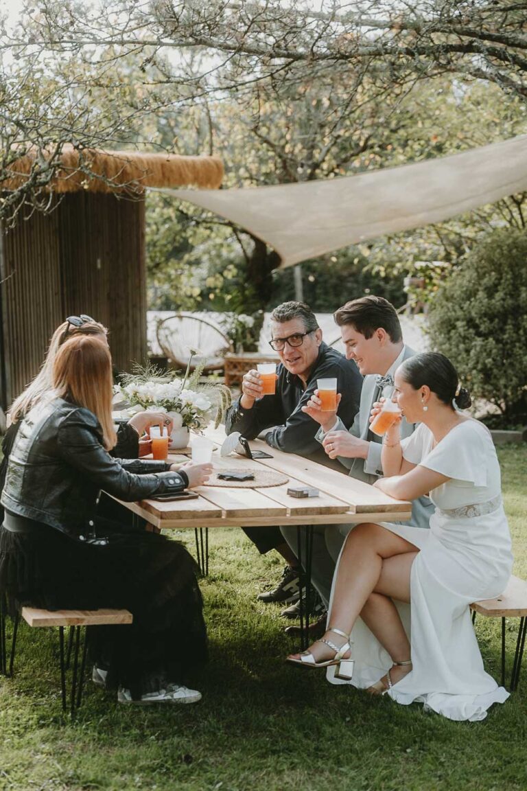 Une famille partage un moment complice à table, entourée de verdure et de lumière naturelle, ambiance douce des Landes.
