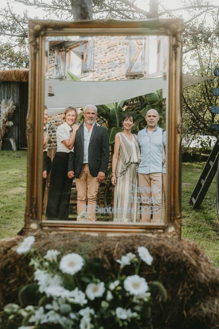 Un doux moment partagé à quatre, reflet capturé dans un miroir fleuri au cœur d'un jardin paisible des Landes.