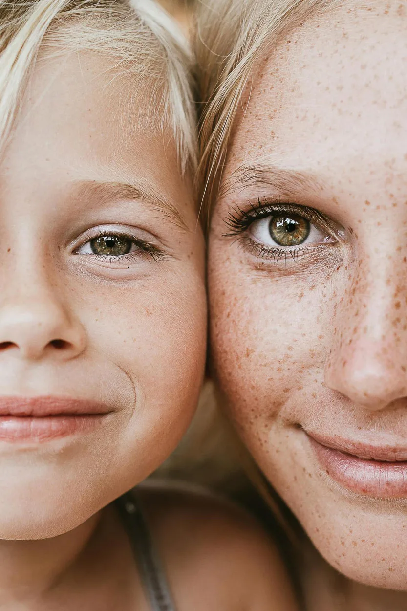 Doux portrait familial dans les Landes : complicité entre un enfant et un parent, sourires tendres, lumière naturelle.