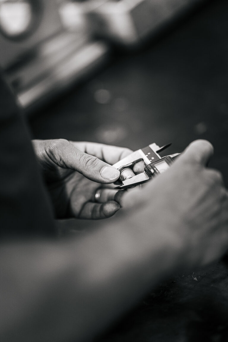 Dans une douce lumière des Landes, des mains précises mesurent avec soin, évoquant tendresse et authenticité intemporelle.