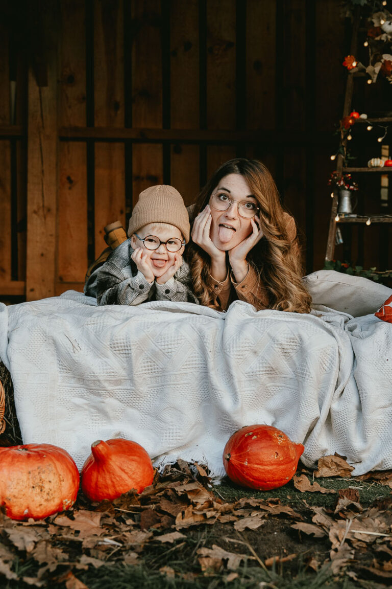 Instant complice entre une maman et son enfant, allongés sur un plaid au cœur des Landes, rires d'automne capturés.