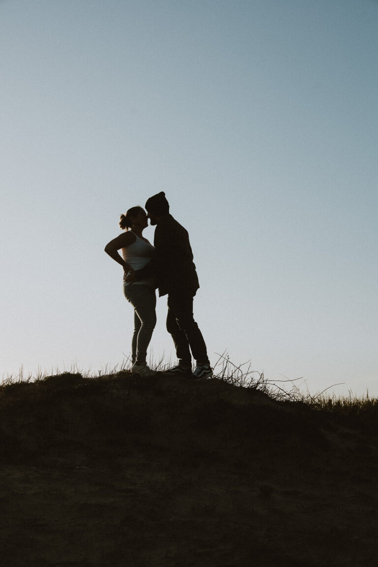 Deux êtres côte à côte, silhouette tendre sur une colline landaise au ciel limpide, signée photographe Dax.
