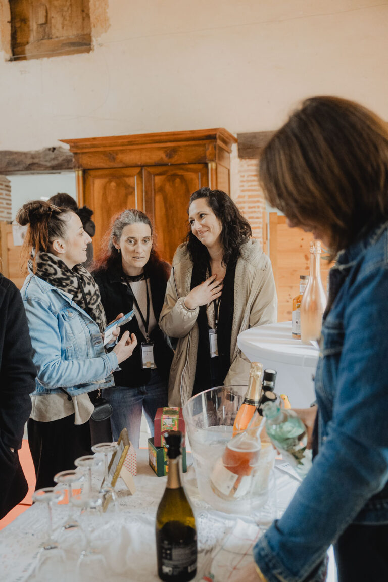 Quatre amies partagent un moment complice autour d'une table, ambiance douce et festive capturée dans les Landes.