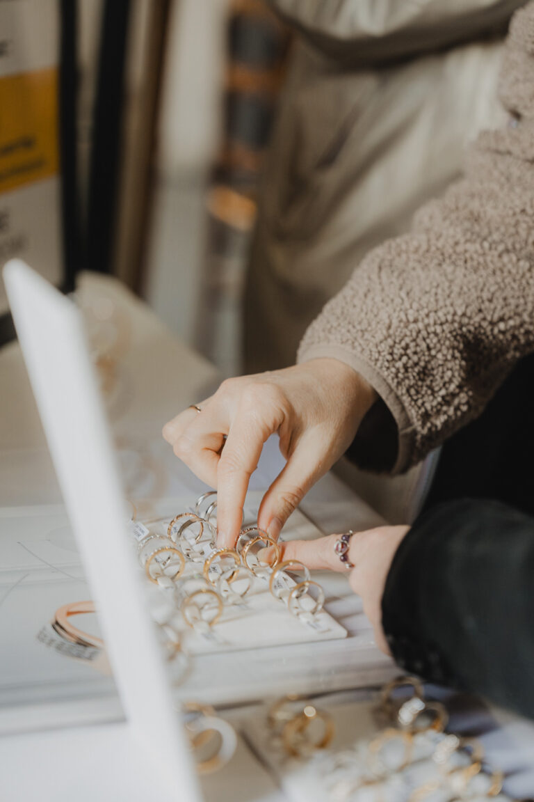 Un doux moment capturé, deux proches choisissent des alliances, gestes tendres dans l'ambiance intime d'une bijouterie landaise.
