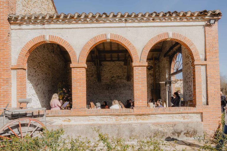 Dans une bâtisse en pierre baignée de soleil, une famille partage un doux moment, parfait pour la photographie dans les Landes.