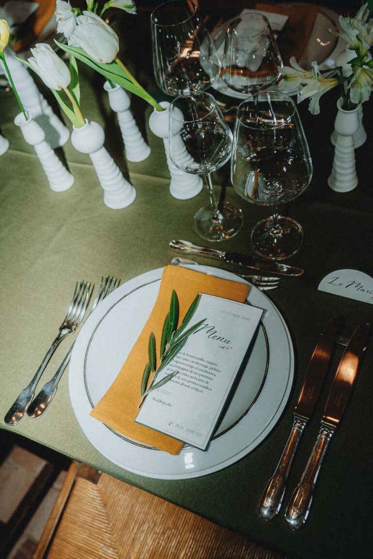 Table élégante, assiette blanche, détails dorés et feuillage sur nappe verte ; ambiance douce idéale pour photos en famille Landes.