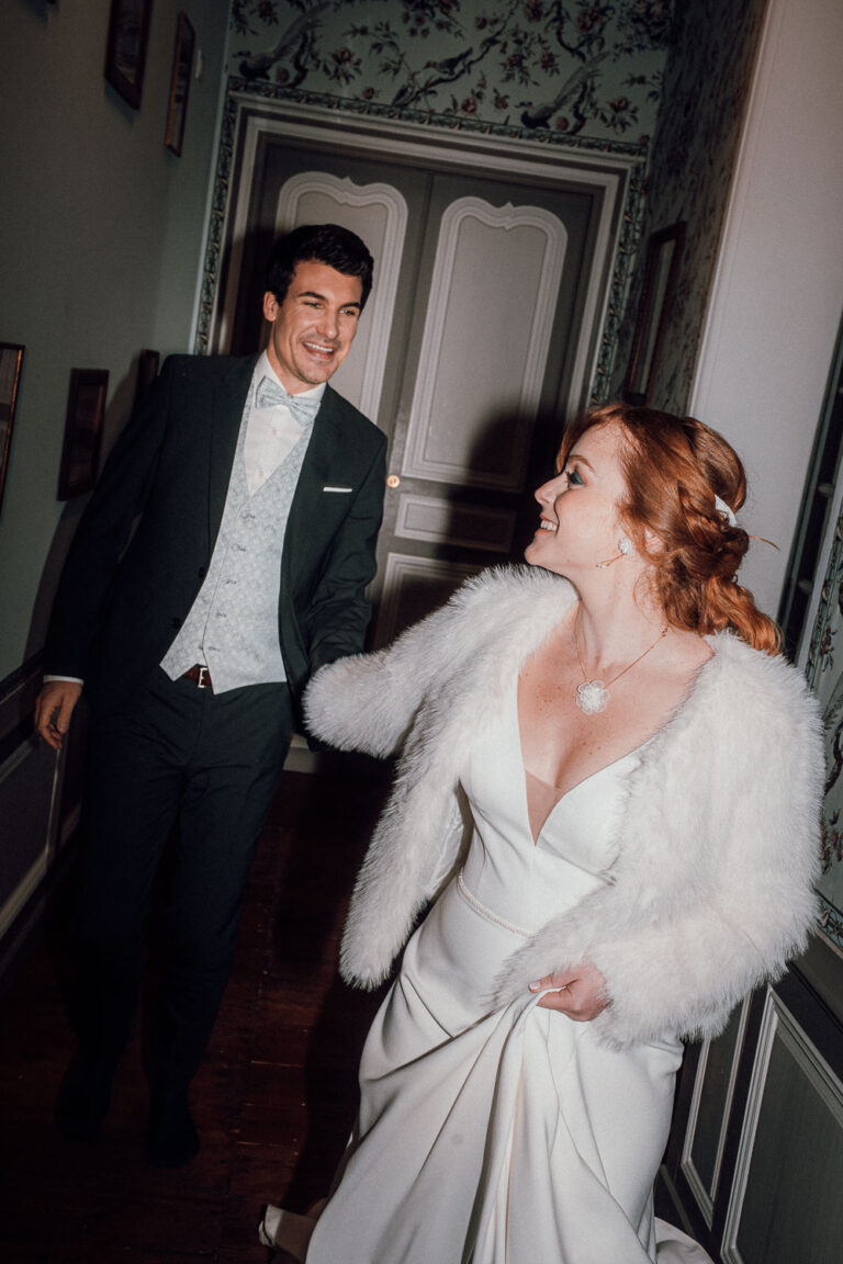 Un couple élégant avance côte à côte dans un couloir lumineux, rieurs, ambiance douce, idéal mariage ou famille Landes.