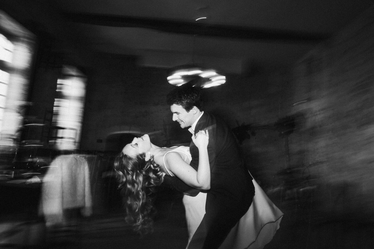Instant tendre en intérieur : un couple souriant danse, capturé par votre photographe famille ou mariage dans les Landes.
