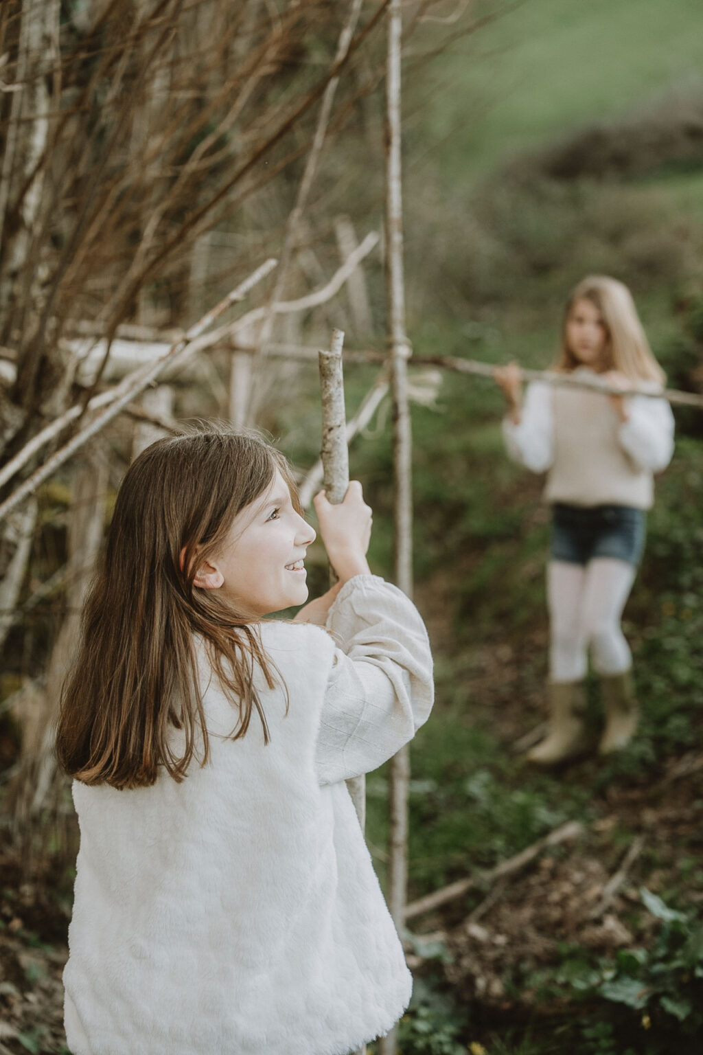 Deux sœurs rient et jouent parmi les pins à Dax : des moments de complicité lors d'une séance photo en famille dans les Landes, dans une ambiance naturelle.