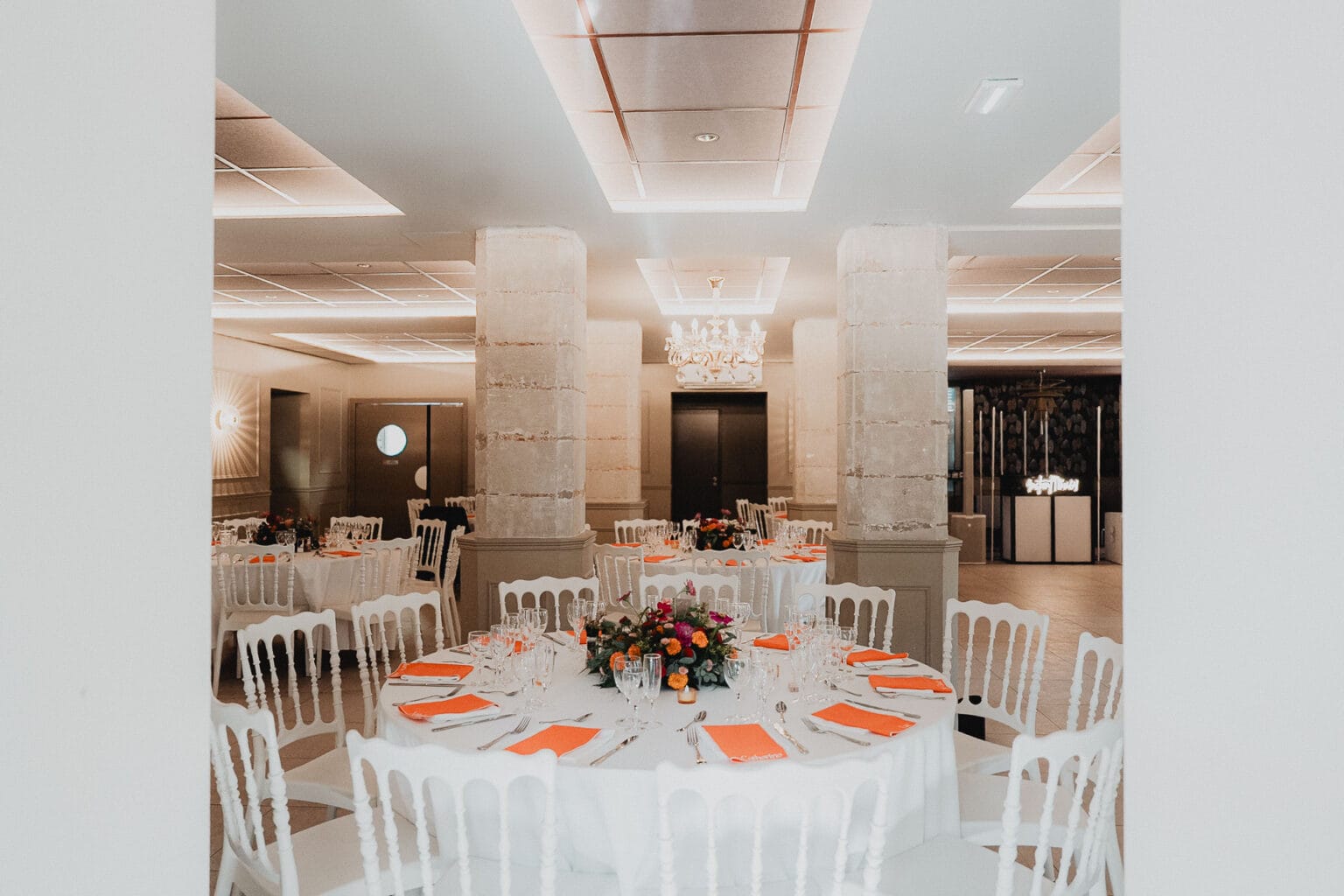 Réception de mariage élégante avec des tables ornées de fleurs dans un domaine en pierre des Landes.