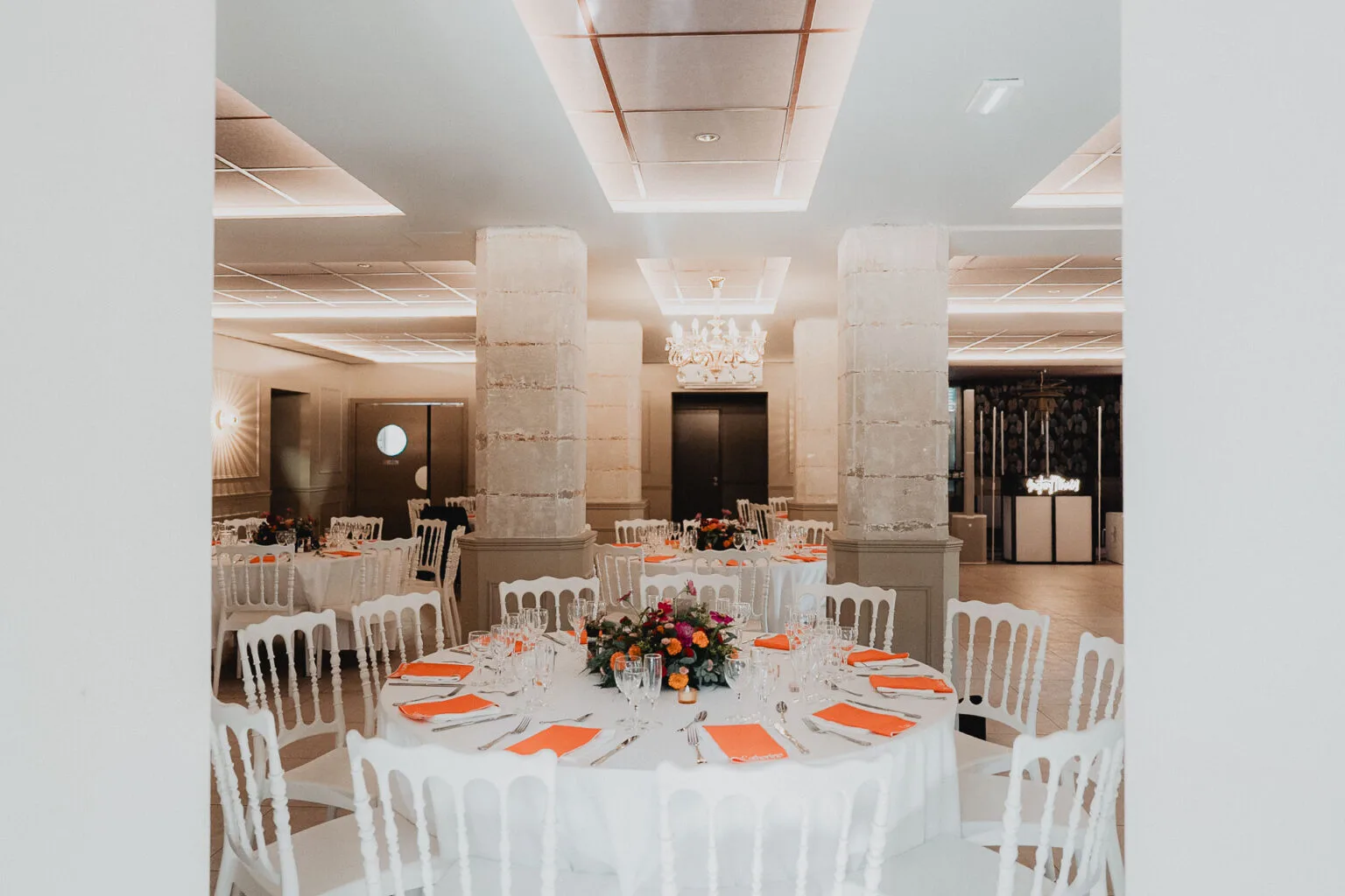 Réception de mariage élégante avec des tables ornées de fleurs dans un domaine en pierre des Landes.