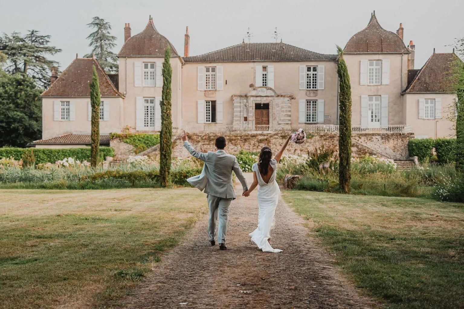 De jeunes mariés rayonnants se dirigeant vers un château dans les Landes pour leur mariage.