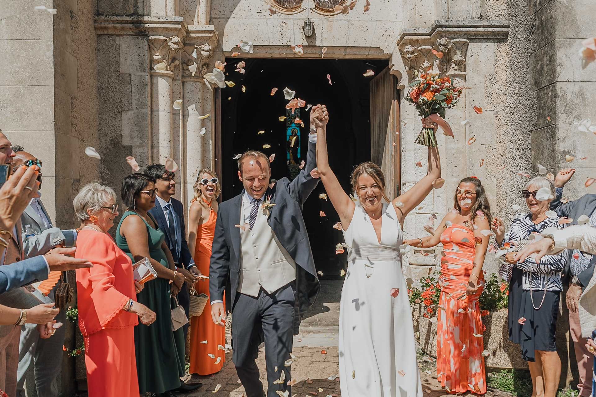 Sortie joyeuse des mariés sous les pétales