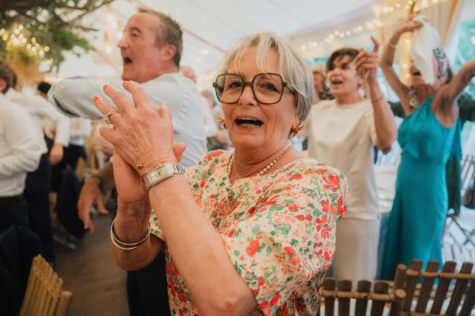 Une invitée applaudit avec enthousiasme pendant la réception