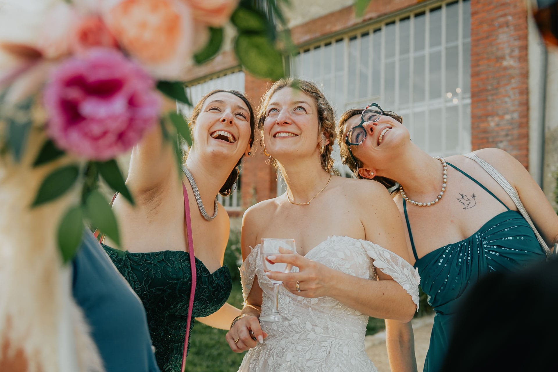 Trois femmes rient ensemble avec un bouquet