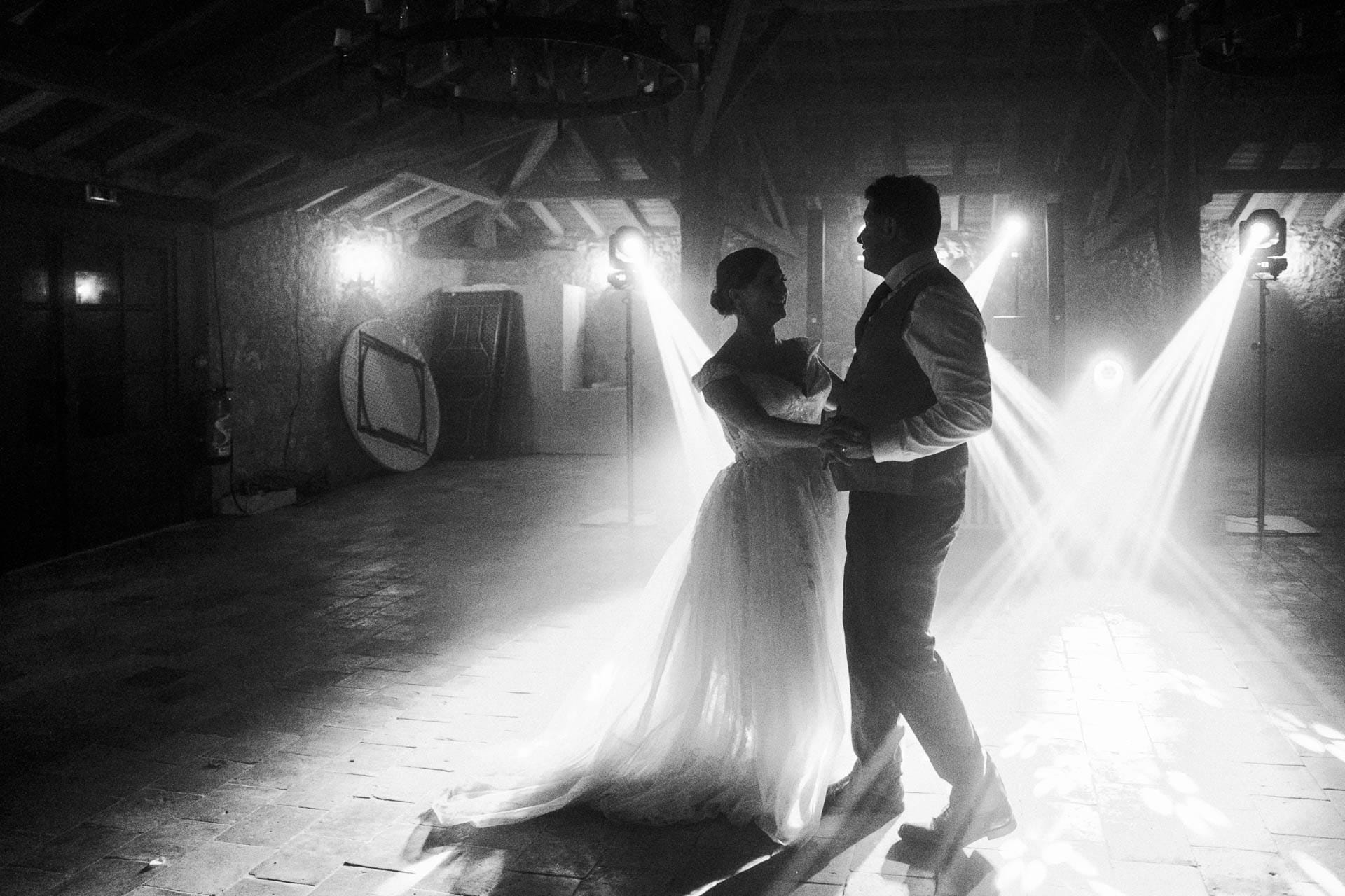 Les mariés dansent en noir et blanc sous les projecteurs