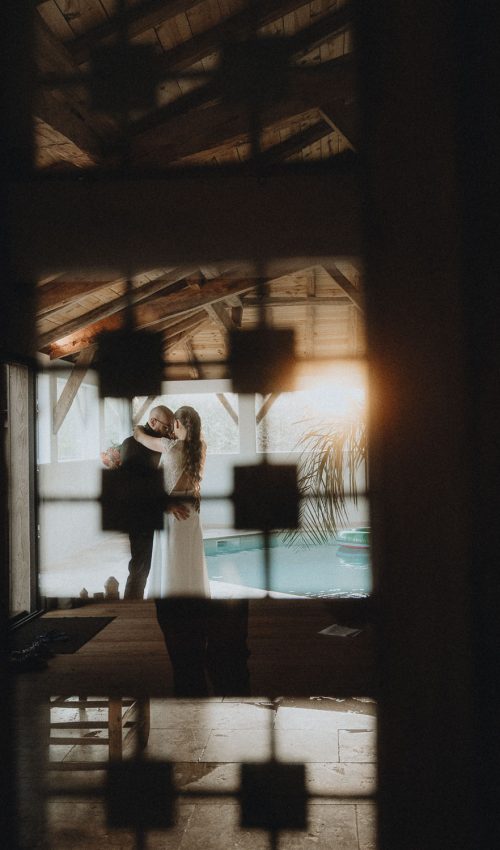 Moment complice d'un couple qui danse dans une pièce ensoleillée, ambiance rustique à Dax, Landes.