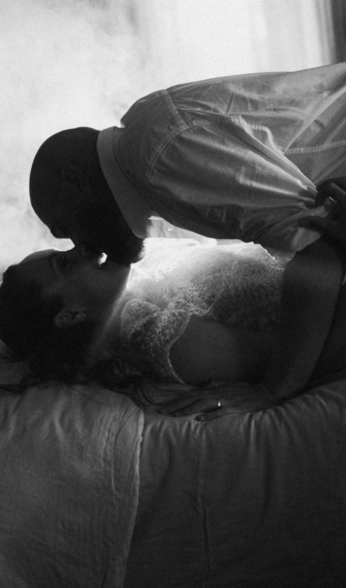 Tendresse d'un couple élégant qui s'embrasse tendrement sur un lit, lumière douce à Dax par Allison Micallef.