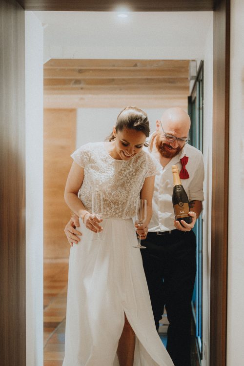 Sourires complices d'un couple élégant dans un couloir près de Dax, séance photo mariage par Allison Micallef.