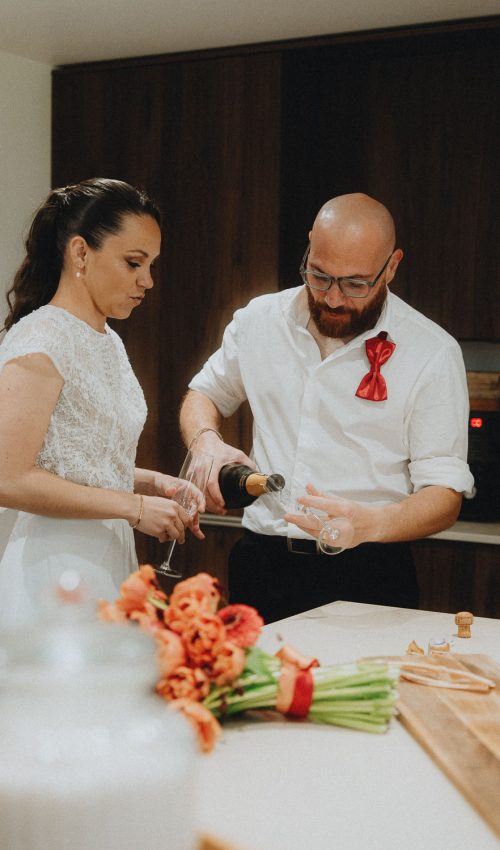 Champagne versé en couple dans une cuisine lumineuse, ambiance chaleureuse à Dax, séance famille Landes.
