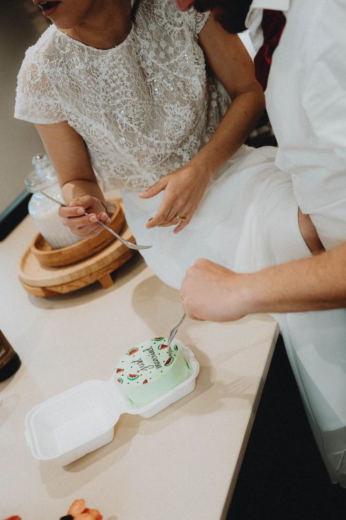 Complicité d'un couple de jeunes mariés partageant un gâteau, instant spontané lors d'un mariage à Dax dans les Landes.