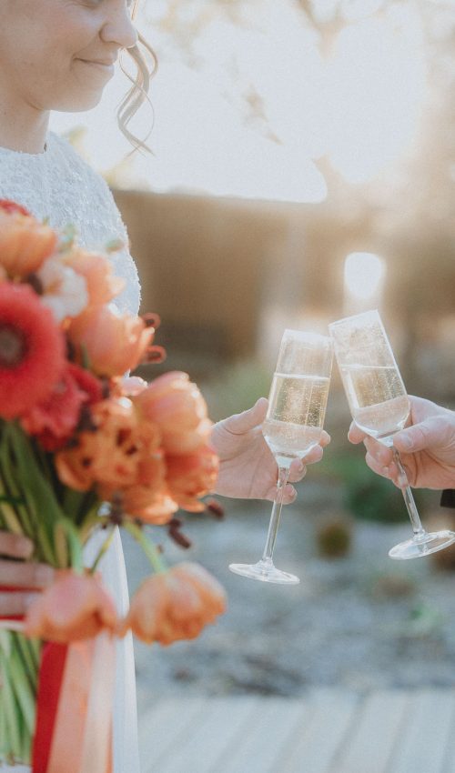 Deux mariés trinquent au coucher du soleil à Dax, bouquet orangé en main, émotions complices capturées dans les Landes.